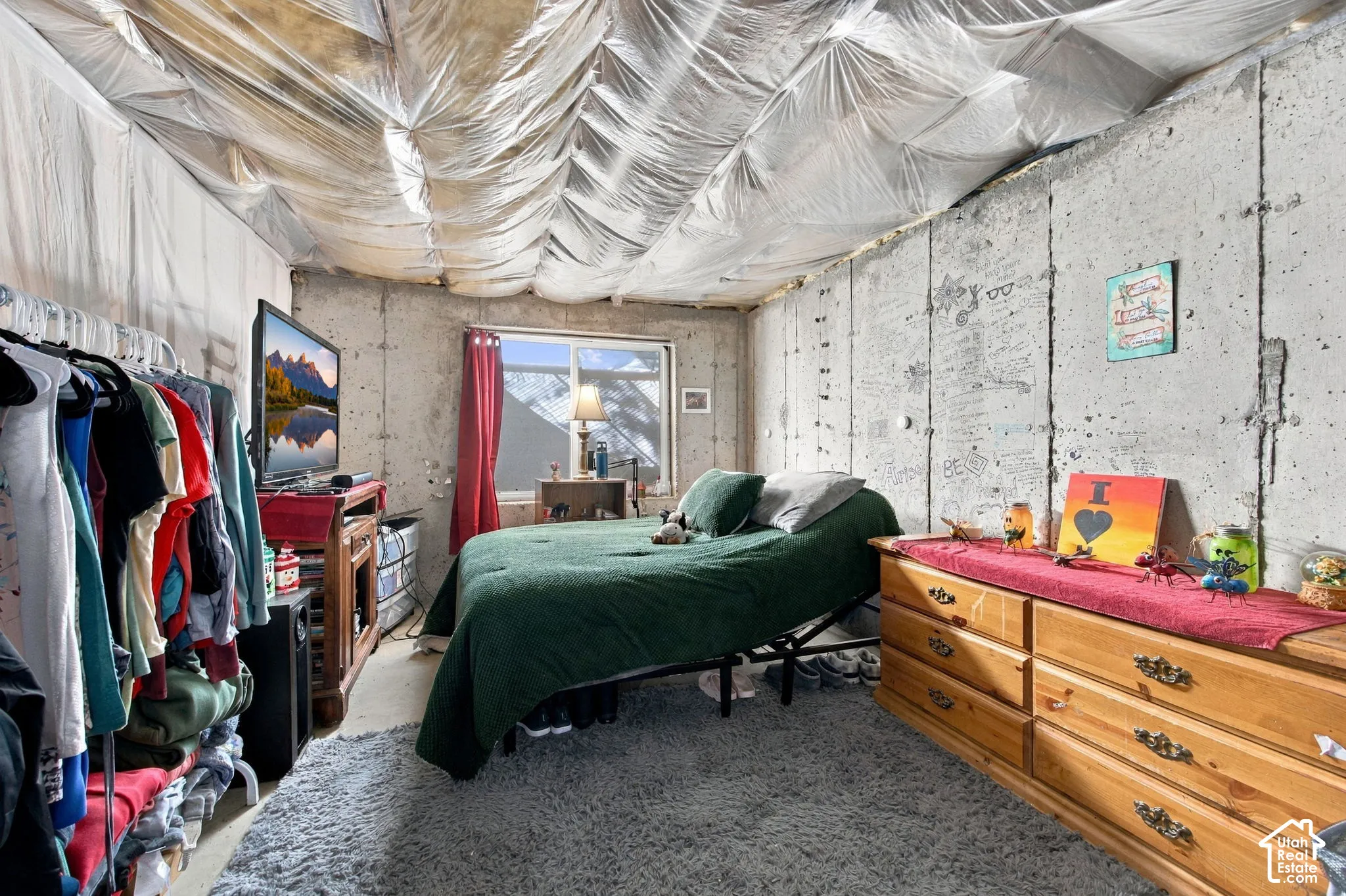 Exposed concrete wall construction, single-pane sliding window, and insulated ceiling treatment