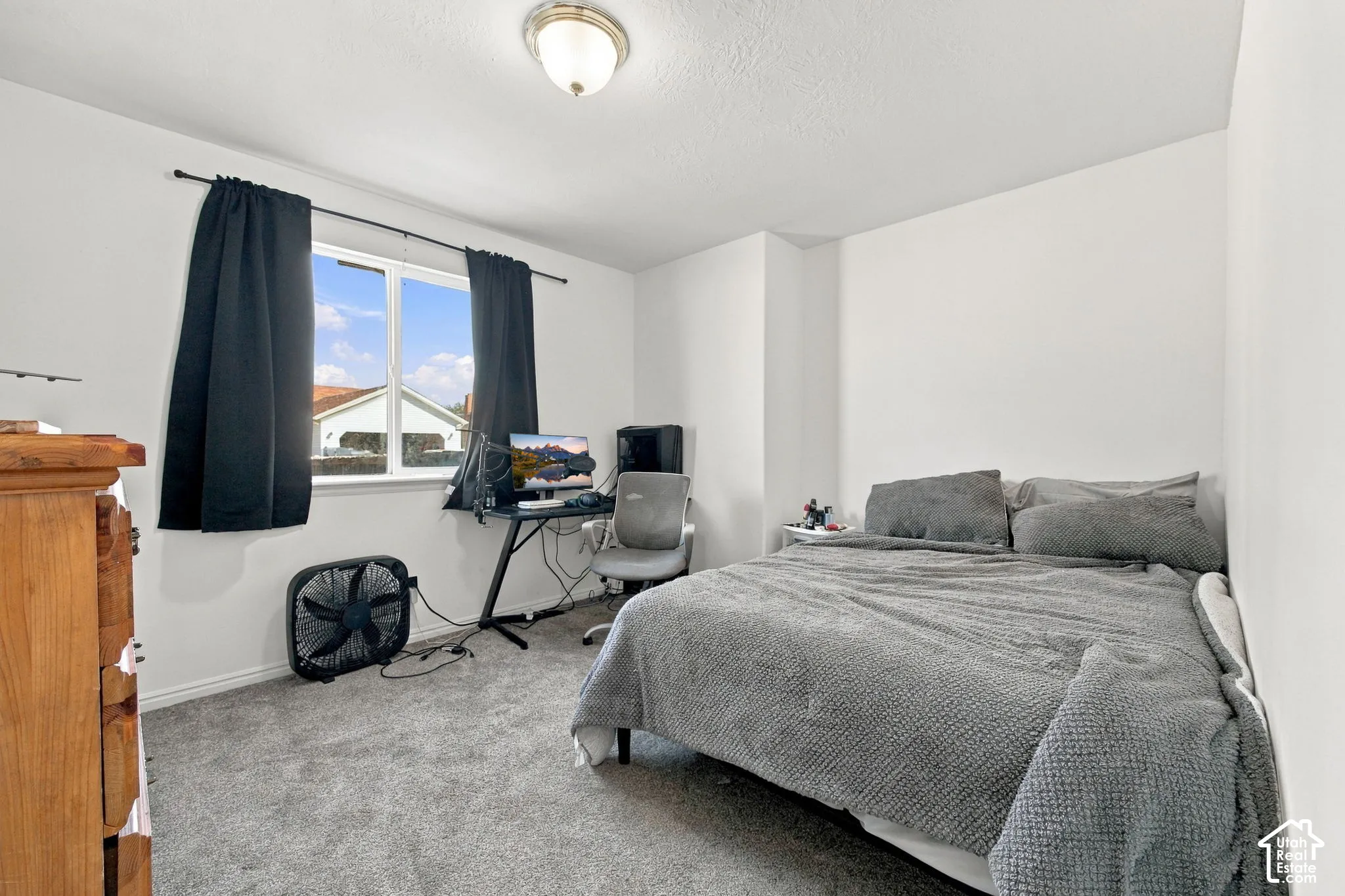 Neutral-toned carpeting, white walls, and a single-pane window featuring a metal frame