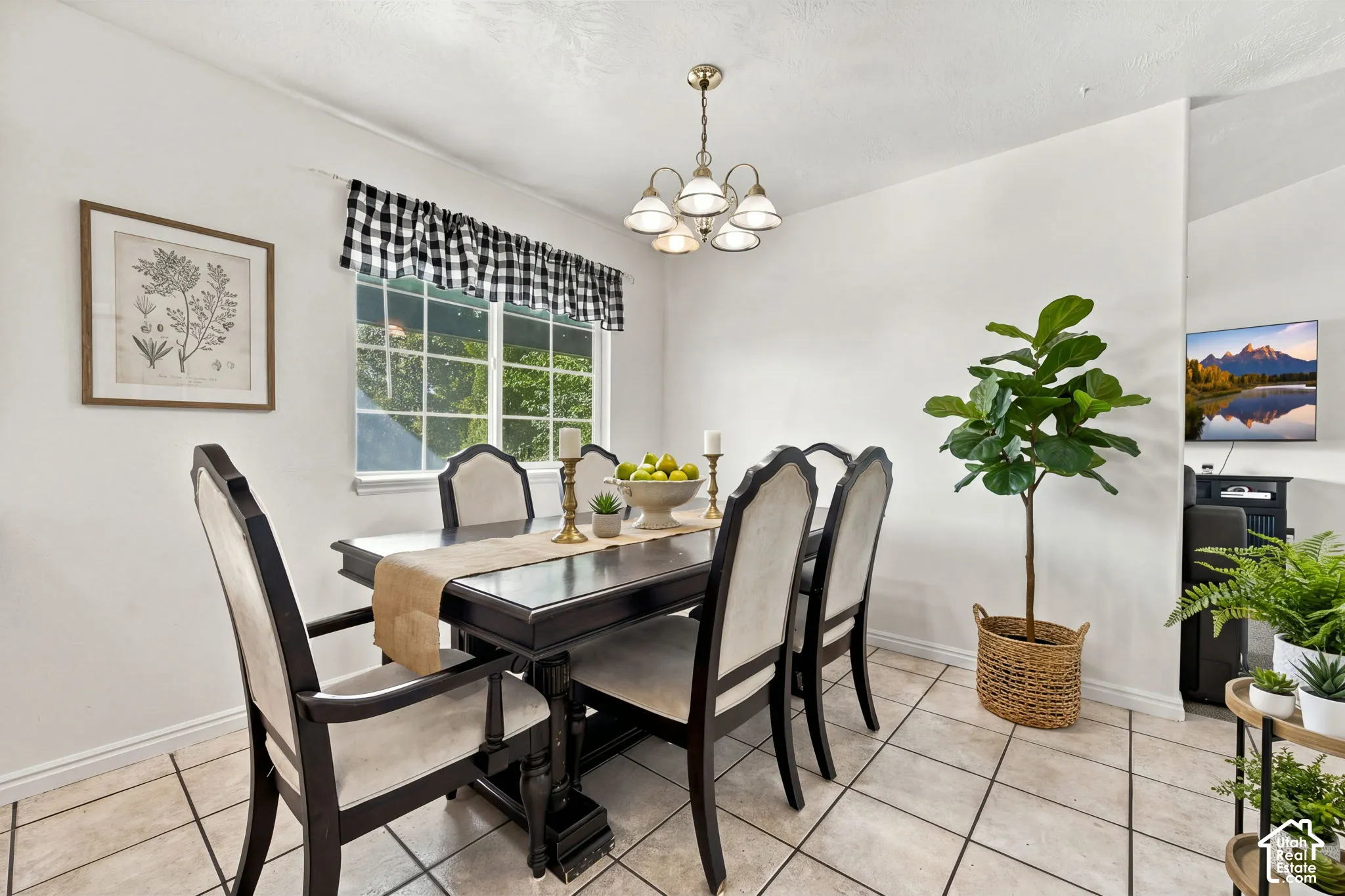 Ceramic tile flooring, multi-pane window with exterior natural light exposure, and a traditional five-light brass-finish chandelier