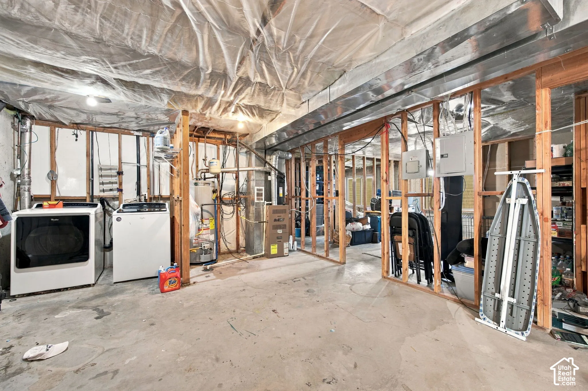Unfinished lower level featuring exposed wood framing, concrete flooring, water heater, furnace, and metal HVAC ductwork