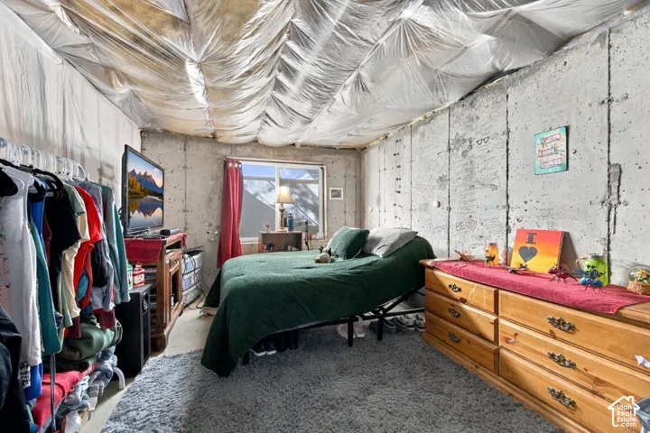 Exposed concrete wall construction, single-pane sliding window, and insulated ceiling treatment