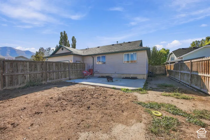 Backyard featuring a concrete patio, wood privacy fencing, and mountain scenery