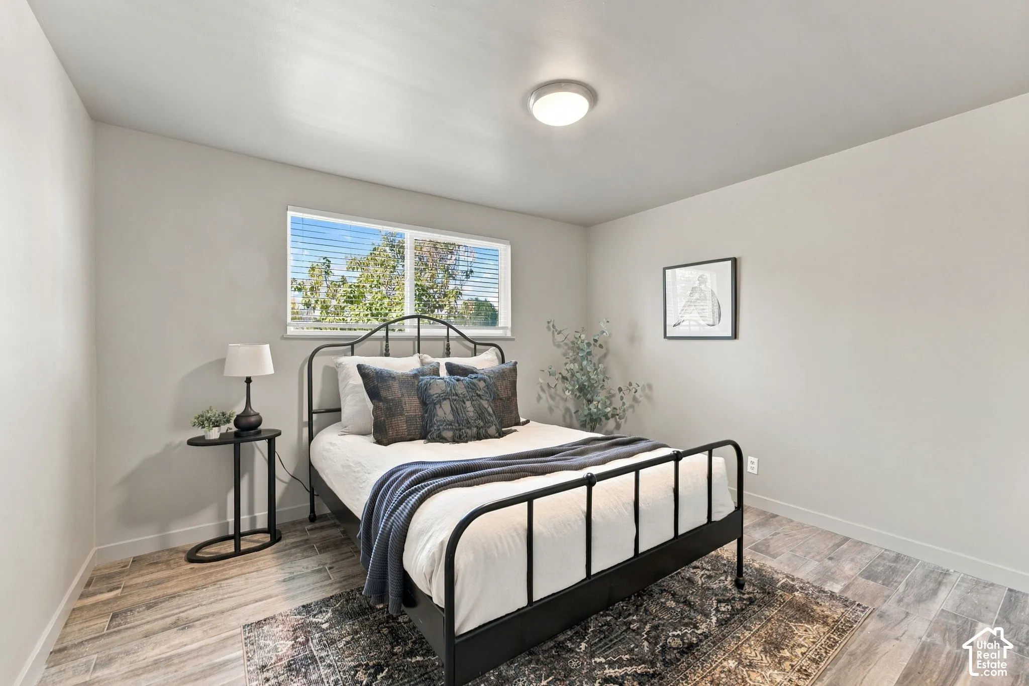 Neutral wall finishes, wood-finish tile flooring, and a sliding window with integrated blinds