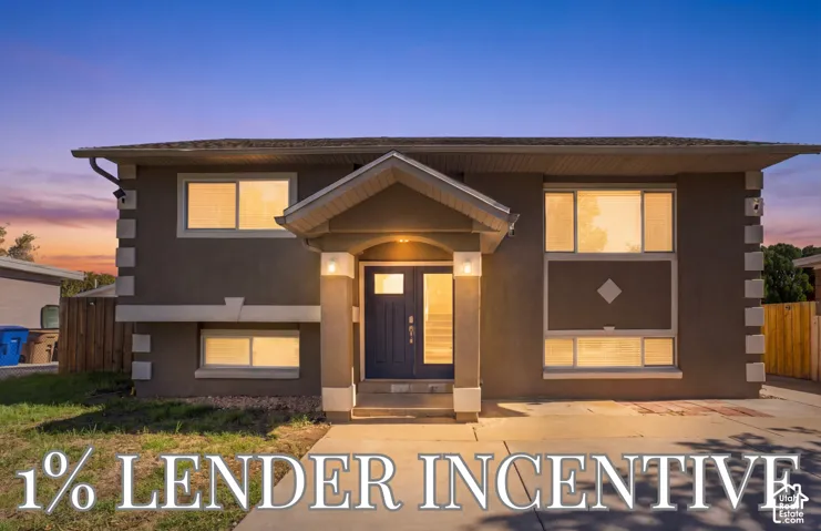 Multi-level exterior featuring a covered entryway, dual-tone facade, decorative quoins, and large horizontal windows