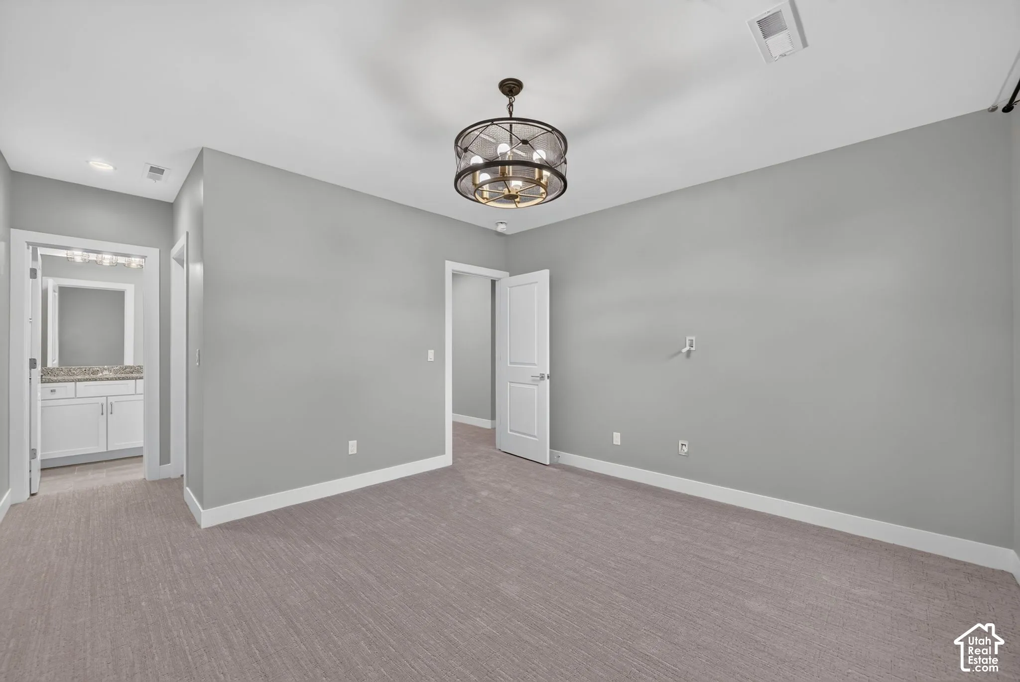 Neutral wall finish, carpeted flooring, multi-light circular drum chandelier, and two-panel interior doors
