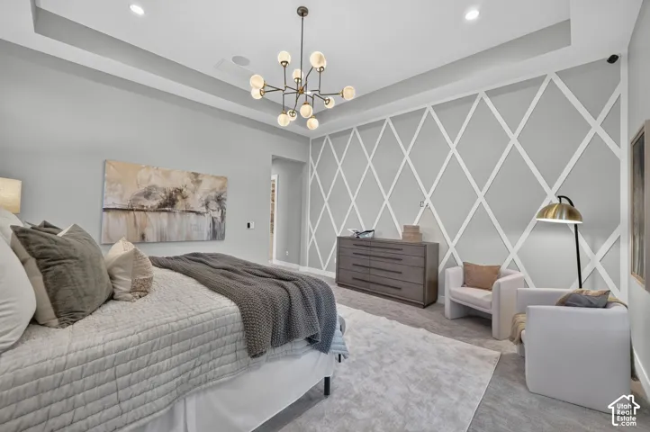 Tray ceiling with recessed lighting, distinctive diamond-patterned accent wall, and multi-arm chandelier