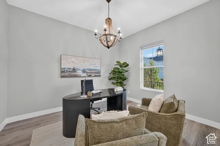 High ceilings featuring a multi-light orb chandelier, wood-finish flooring, and a window with neutral-toned trim