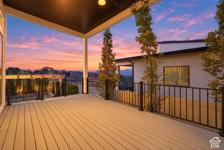 Covered deck featuring composite decking, black metal railing, and recessed ceiling lighting