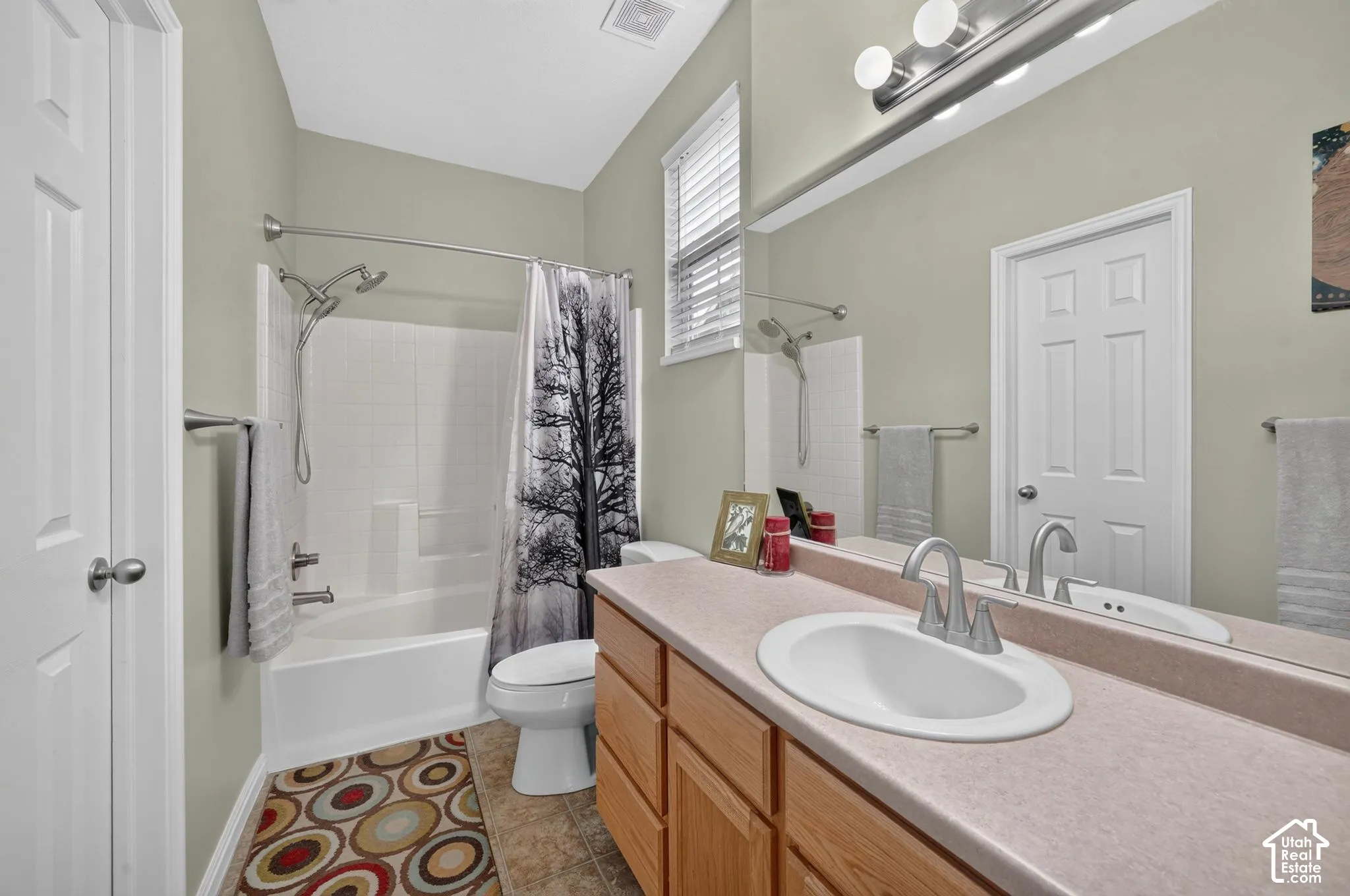 Primary bathroom with vanity and tub/shower combination.