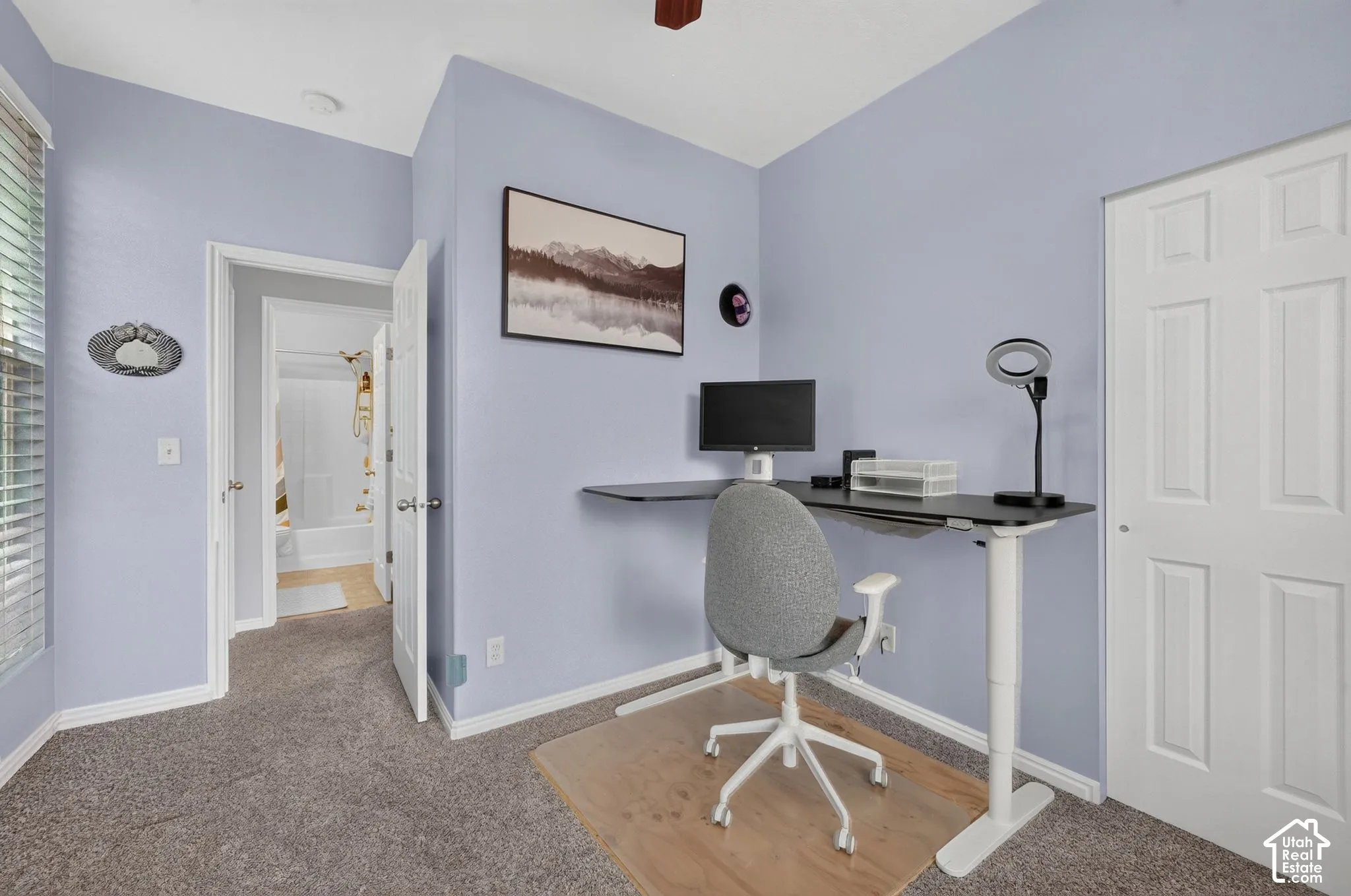 Room featuring neutral wall tones, window blinds, carpeting, and a four-panel interior door