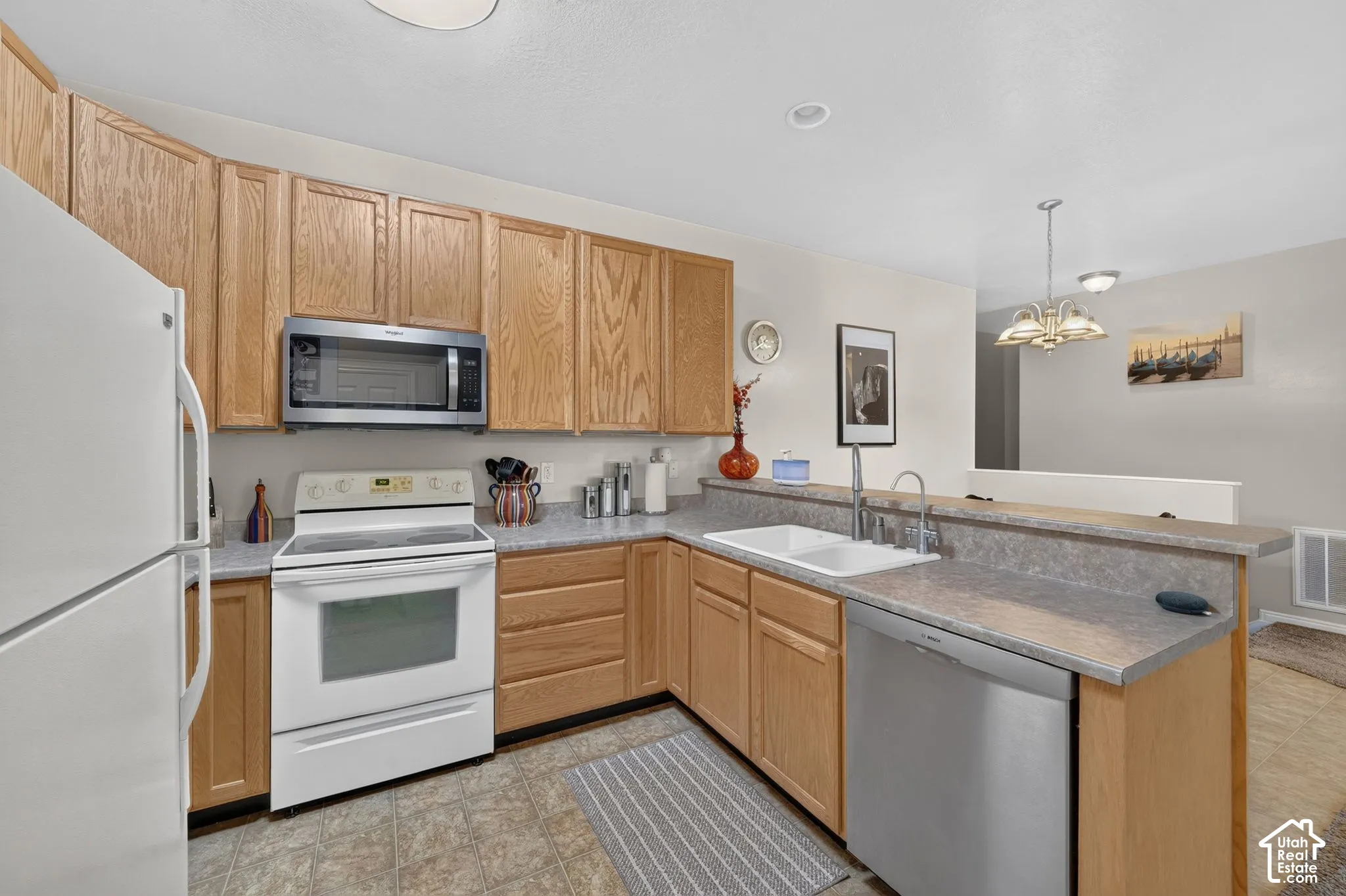 Kitchen with wood cabinetry, breakfast bar and mixed-finish appliances.