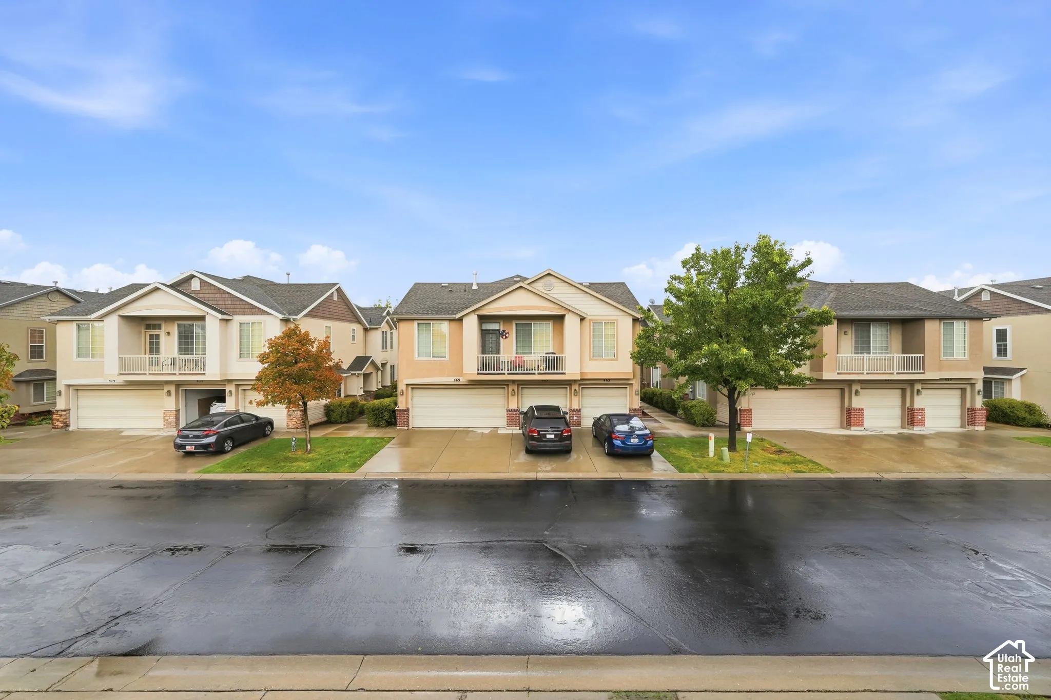 Multi-level exterior featuring stucco and stone siding, gabled rooflines, attached garages, and private covered balconies