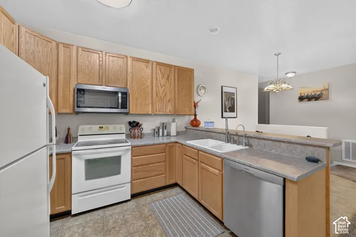 Kitchen with wood cabinetry, breakfast bar and mixed-finish appliances.