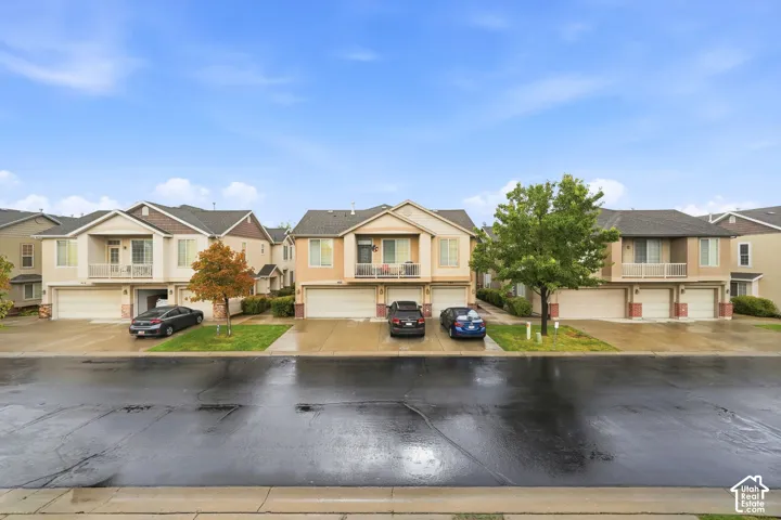 Multi-level exterior featuring stucco and stone siding, gabled rooflines, attached garages, and private covered balconies