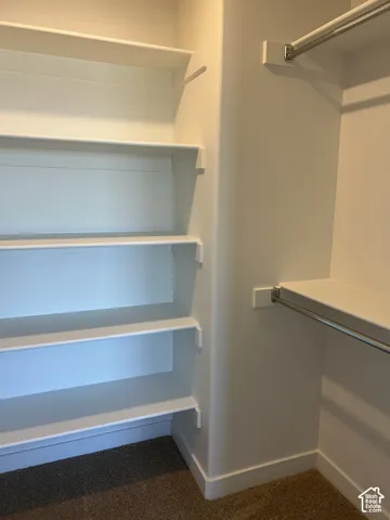 Custom closet featuring tiered built-in shelving and horizontal metal hanging rods