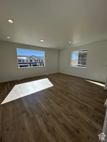 Spacious interior featuring wood-finish flooring, recessed lighting, and multiple large windows