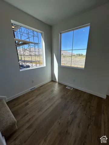 Interior room featuring wood-finish flooring, two expansive windows, and mountain scenery