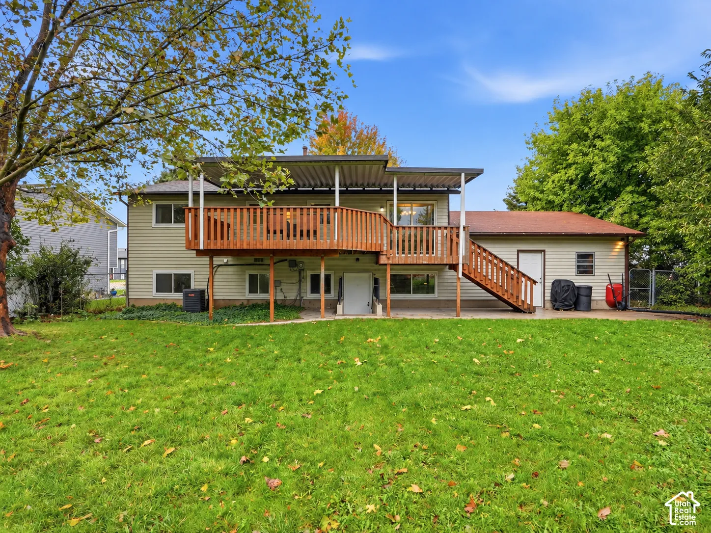 Rear exterior featuring horizontal siding, a covered elevated wood deck with stairs, and a concrete patio