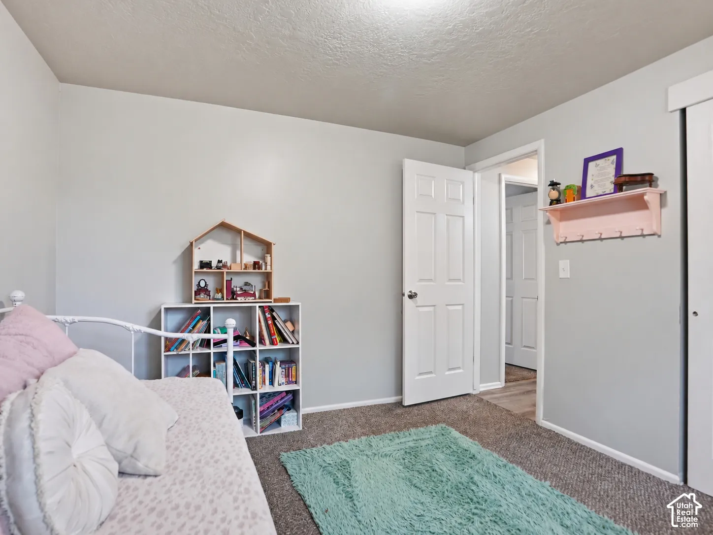 Neutral-toned walls, textured wall-to-wall carpeting, and a six-panel interior door