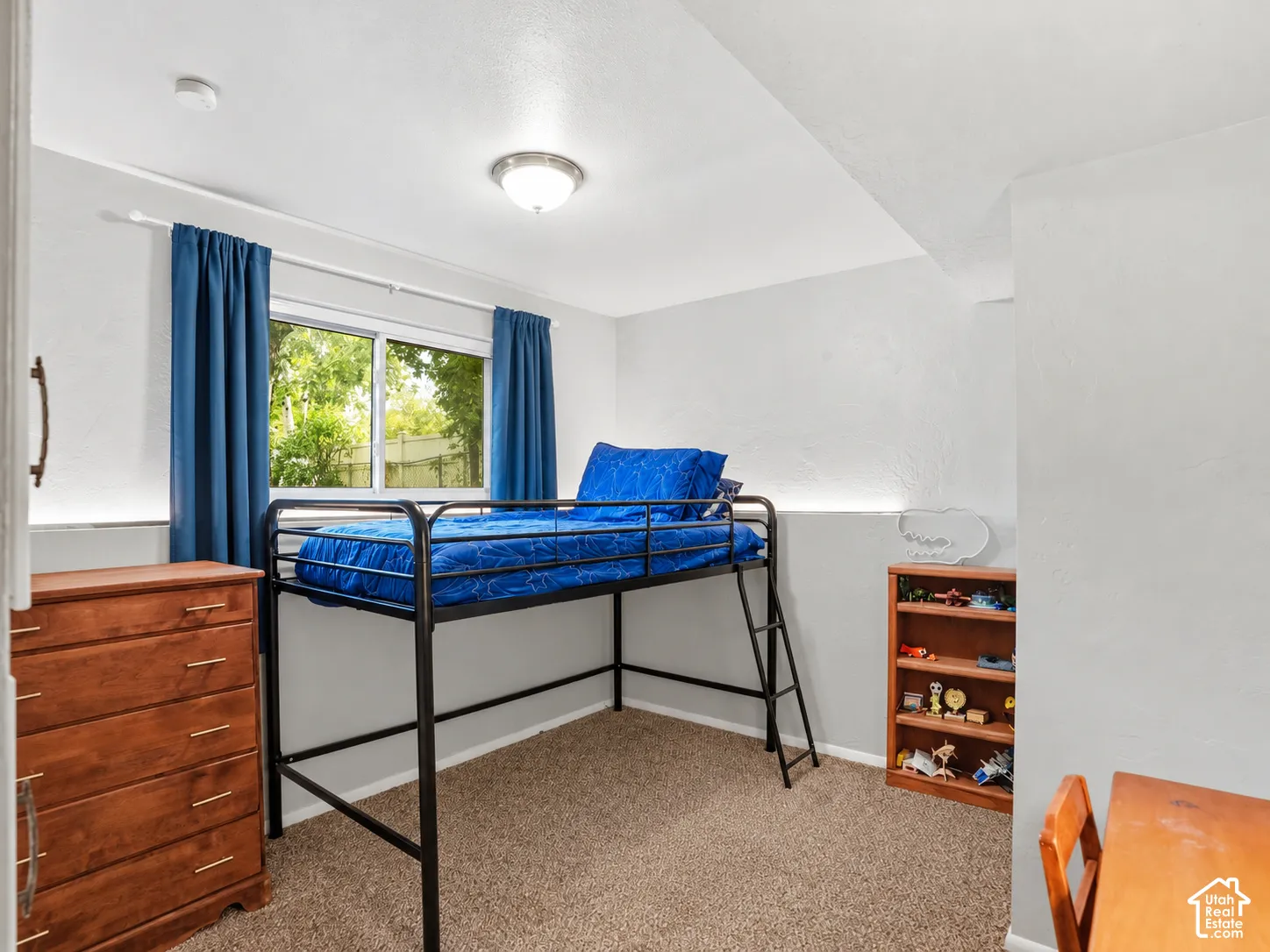 Neutral-toned walls, wall-to-wall carpeting, and a sliding window with horizontal muntins