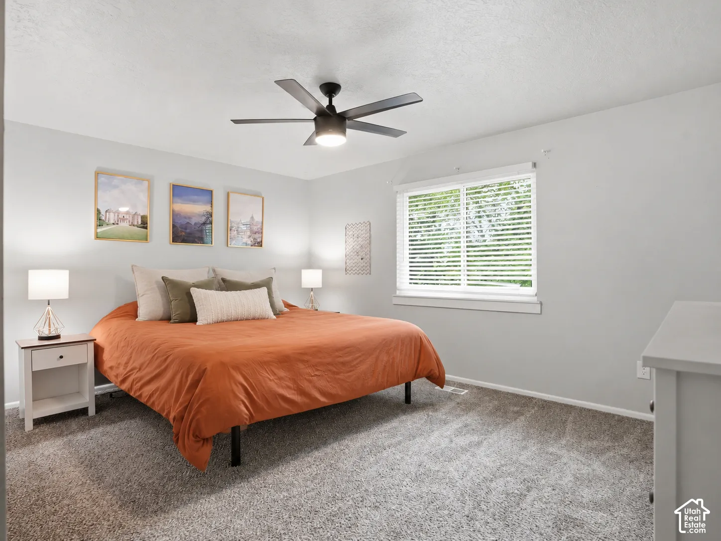 Bedroom featuring neutral wall paint, gray carpeting, a multi-blade ceiling fan with integrated lighting, and a large window with horizontal blinds