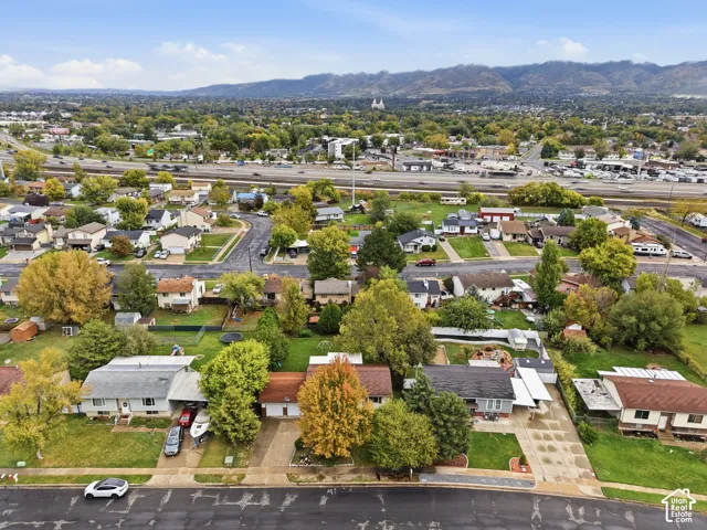 Aerial perspective of residential neighborhood featuring mature trees and expansive mountain range backdrop