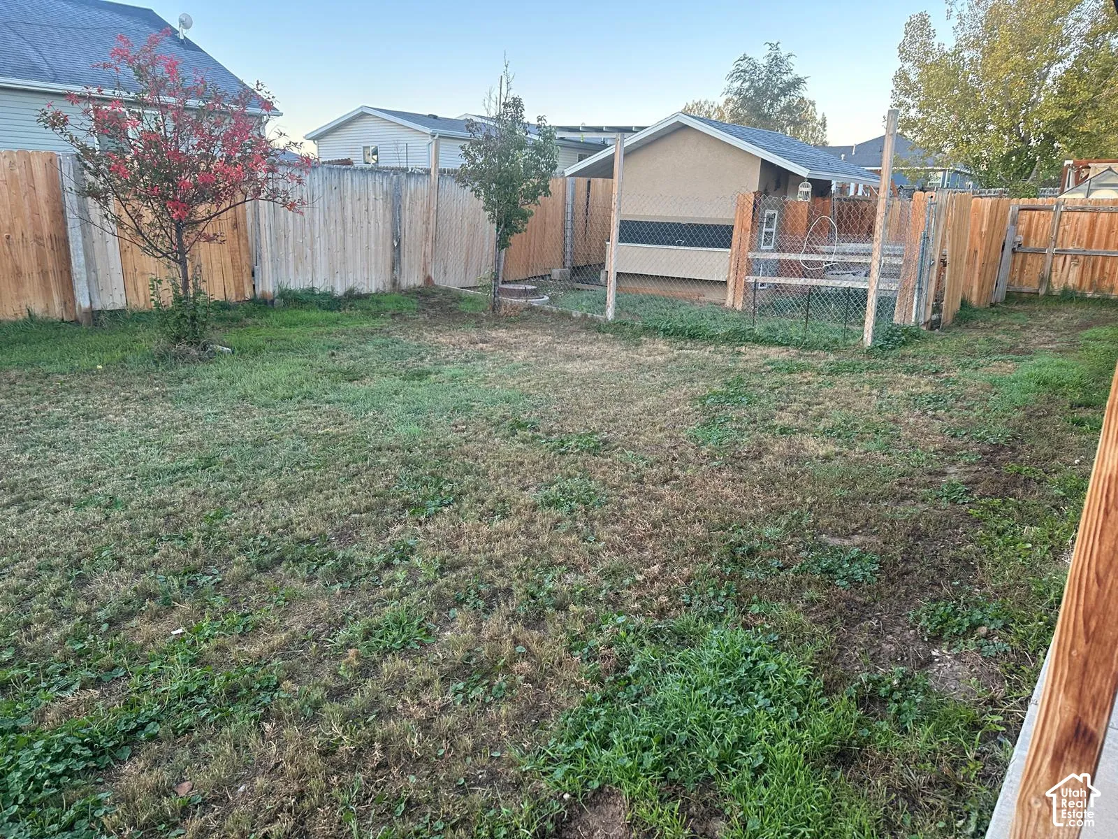 Backyard featuring wood fencing, a detached storage structure, and perimeter landscaping