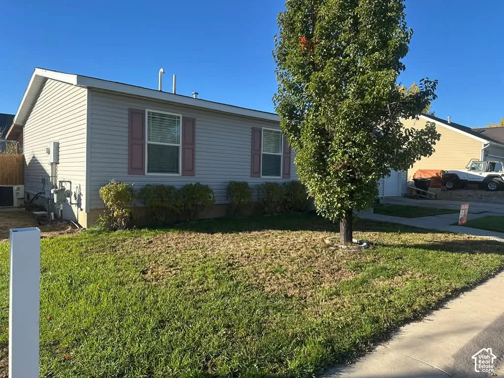 Single-story exterior featuring light-colored horizontal siding, decorative shutters, and mature landscaping
