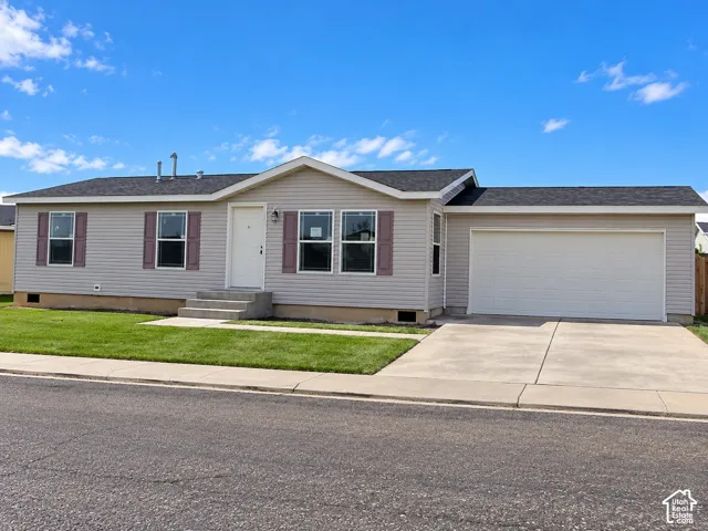 Siding exterior with dark shutters, attached garage, concrete driveway, and front entry steps