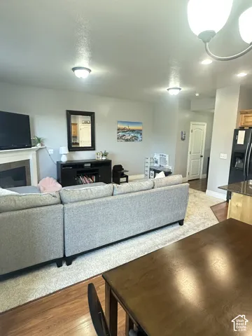 Open-concept interior featuring a fireplace with a mantel, recessed and decorative lighting, neutral wall paint, and a combination of carpeted and wood-finish flooring