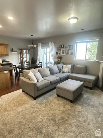 Open-concept interior featuring wood-finish flooring, recessed lighting, a chandelier, a sliding glass door, and large windows
