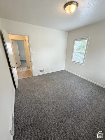 Interior space featuring wall-to-wall carpeting, a single-hung window, and a dome-style flush-mount ceiling light fixture