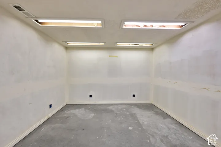 Interior room featuring drywall-finished walls and recessed fluorescent lighting fixtures