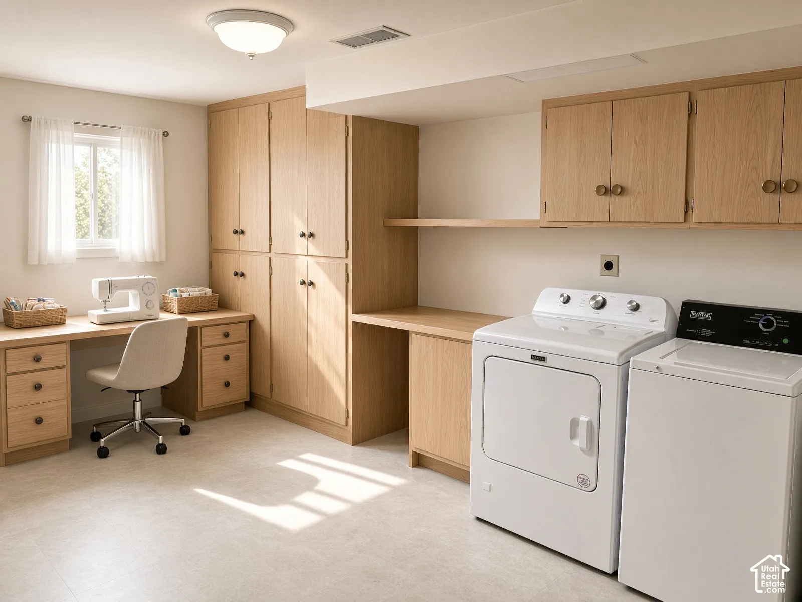 Custom-built light oak cabinetry featuring floor-to-ceiling storage, an integrated desk surface with multiple drawers, and overhead wall-mounted shelving