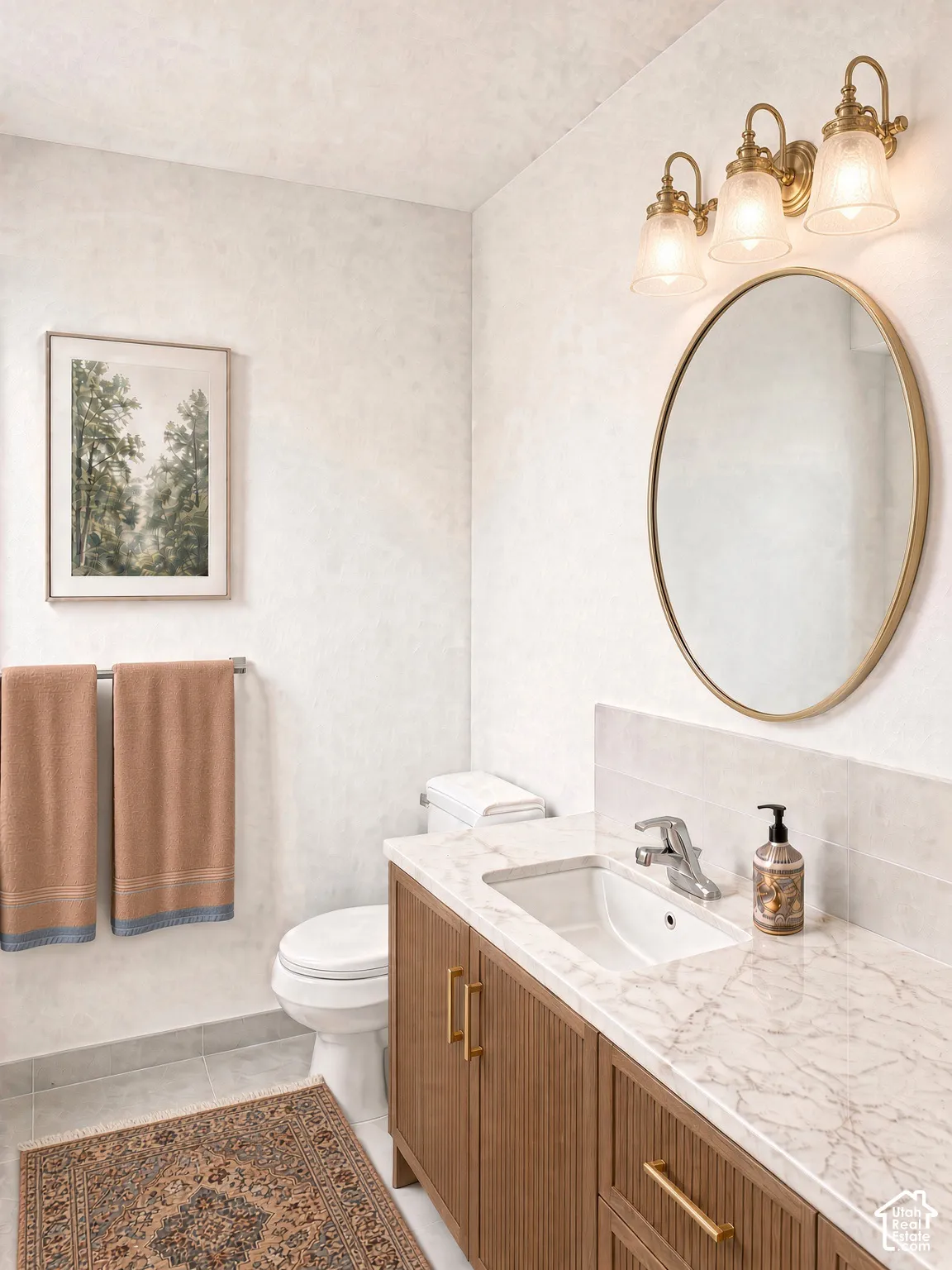 Custom vanity featuring reeded wood-finish cabinetry, stone-style countertop, integrated sink, and brass-tone hardware, complemented by a tri-light fixture and oval-shaped mirror