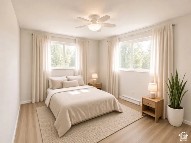 Neutral-toned room featuring wood-finish flooring, dual windows with curtain rods, and a central ceiling fan with integrated lighting