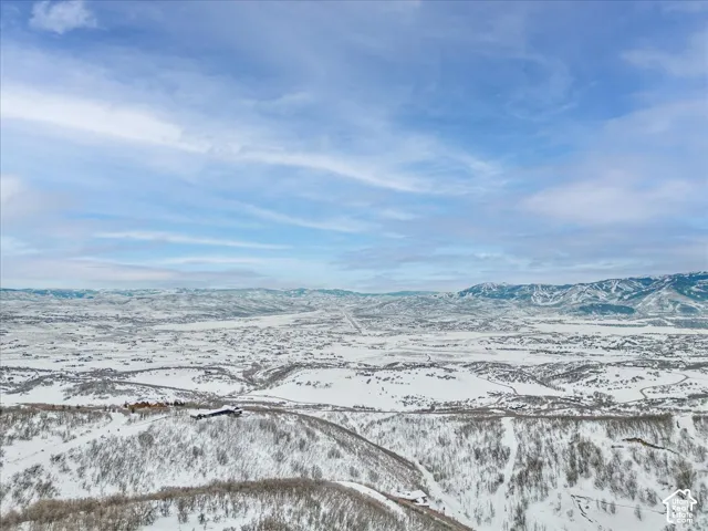 Aerial perspective featuring an expansive mountain landscape, elevated terrain, and distant peaks
