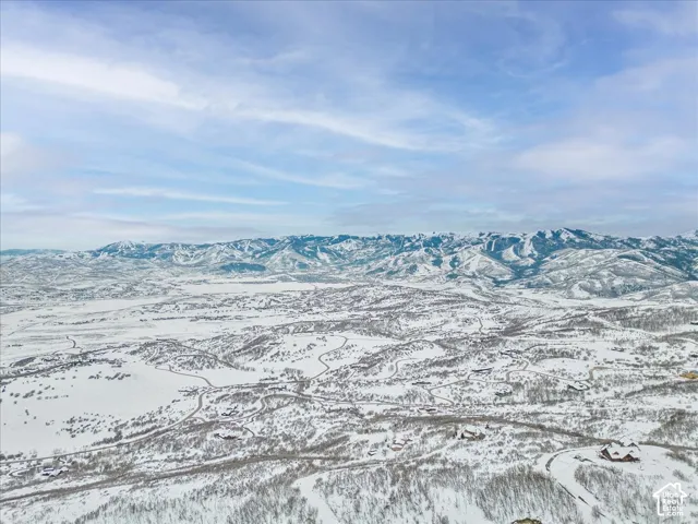 Elevated topography featuring snow-capped mountain ranges and expansive alpine terrain