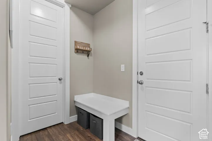 Built-in white bench seating, five-panel doors with satin nickel hardware, and dark wood-finish flooring