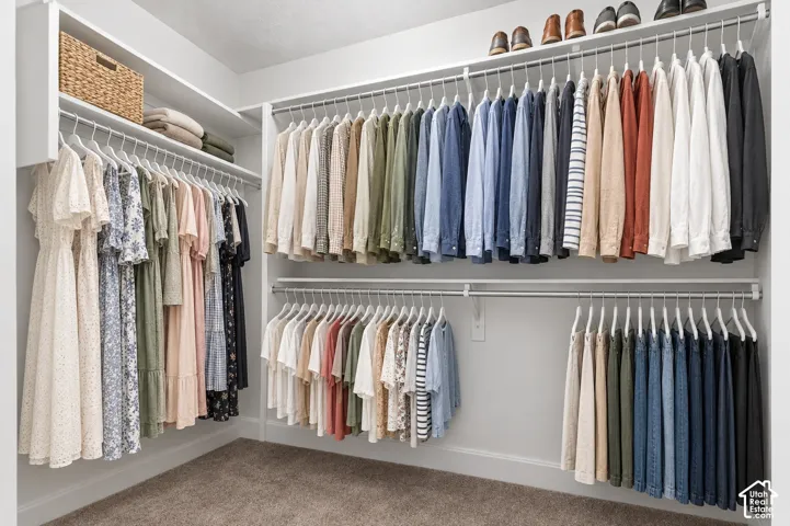 Walk-in closet featuring multi-level metal hanging rods and integrated upper shelving