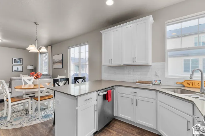 Kitchen featuring white shaker-style cabinetry, quartz countertops, a white subway tile backsplash, stainless steel appliances, and wood-finish flooring