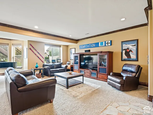 Living area featuring recessed lighting, crown molding, a bay window, and a built-in wooden media cabinet