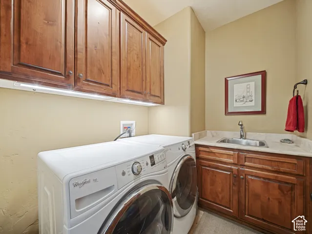 Laundry space featuring stained-wood cabinetry, stone-finish countertops, and a drop-in stainless steel sink with a high-arch faucet