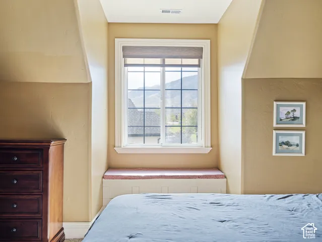 Built-in window bench with inset panel detail, grid-patterned window, and vaulted ceiling lines