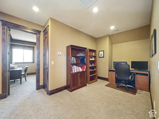 Neutral carpet flooring, rich wood-stained door and window casings, and recessed ceiling lighting