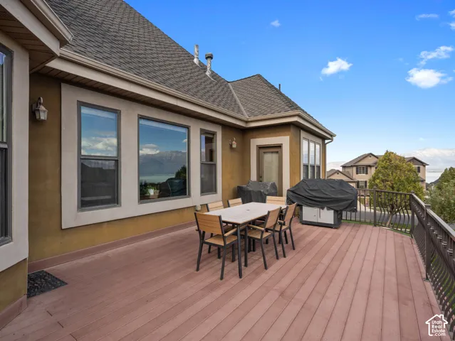Expansive deck featuring composite decking, decorative metal railings, and stucco exterior walls