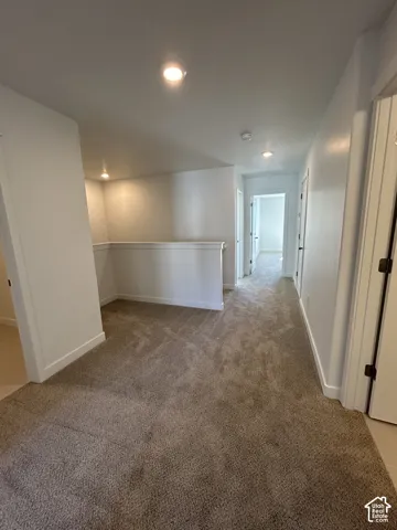 Neutral-toned carpeting, recessed ceiling lighting, and solid-core interior doors
