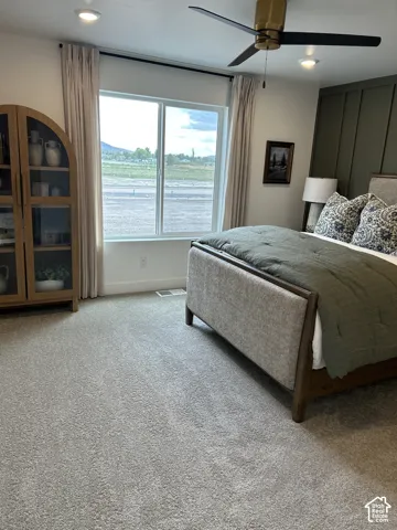 Bedroom featuring a dark-toned vertical board-and-batten accent wall, recessed lighting, and a modern metal ceiling fan with a metallic finish
