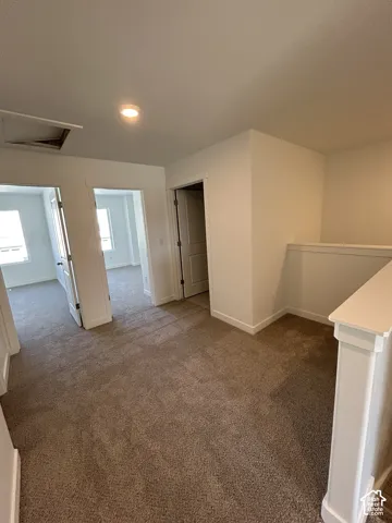 Neutral-toned carpet flooring, recessed ceiling lighting, and solid-core interior doors