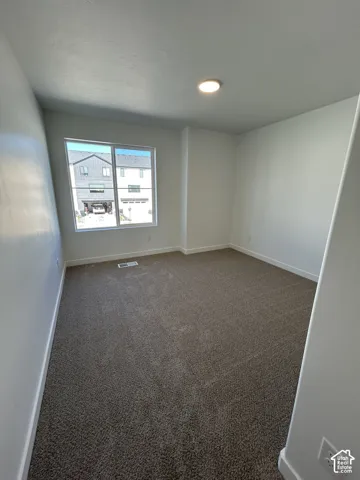Neutral-toned carpeted flooring, smooth wall finish, and flush-mount ceiling lighting with a single-pane sliding window